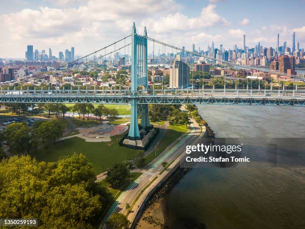 view of robert f. kennedy bridge and manhattan on a bright day - queens - new york city stock pictures, royalty-free photos & images