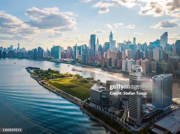 aerial of roosevelt island and downtown manhattan on a cloudy day - midtown manhattan stockfoto's en -beelden