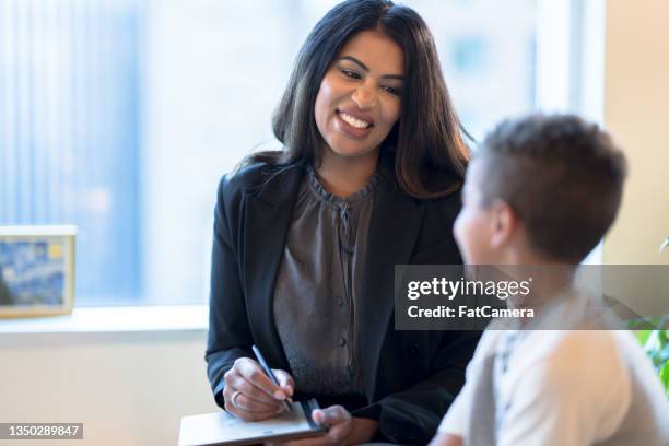 therapist warmly encouraging a young boy - counseling stockfoto's en -beelden