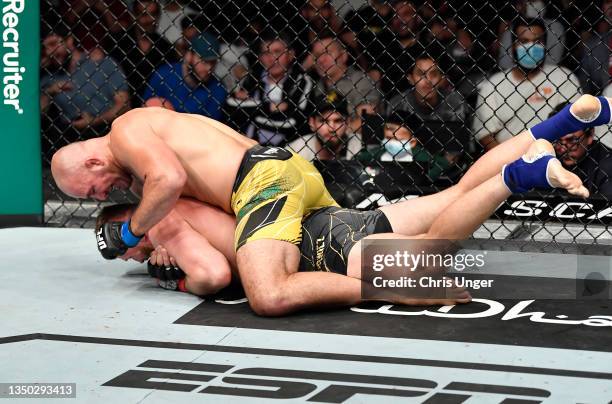 Glover Teixeira of Brazil works for a rear choke submission against Jan Blachowicz of Poland in the UFC light heavyweight championship fight during...