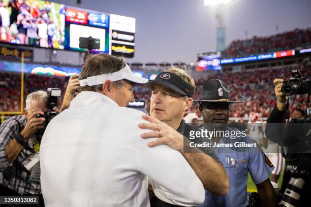 Head coach Kirby Smart of the Georgia Bulldogs meets with head coach Dan Mullen of the Florida Gators after a game at TIAA Bank Field on October 30,...