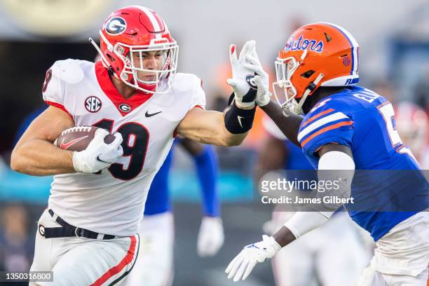 Brock Bowers of the Georgia Bulldogs runs for yardage against Kaiir Elam of the Florida Gators during the second half of a game at TIAA Bank Field on...