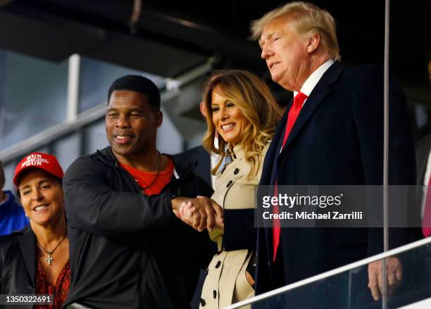 Former football player and political candidate Herschel Walker interacts with former president of the United States Donald Trump prior to Game Four...