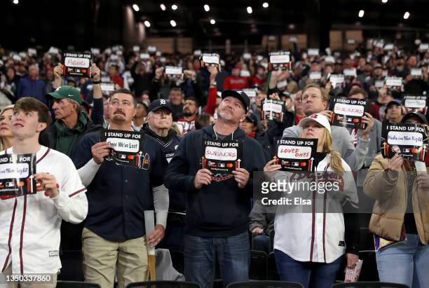 Fans hold up signs for "stand up to cancer" prior to the sixth inning in Game Four of the World Series between the Houston Astros and the Atlanta...