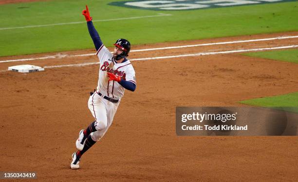 Dansby Swanson of the Atlanta Braves celebrates as he rounds the bases after hitting a solo home run against the Houston Astros during the seventh...