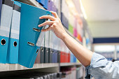 Male hand choosing file folder in stationery shop