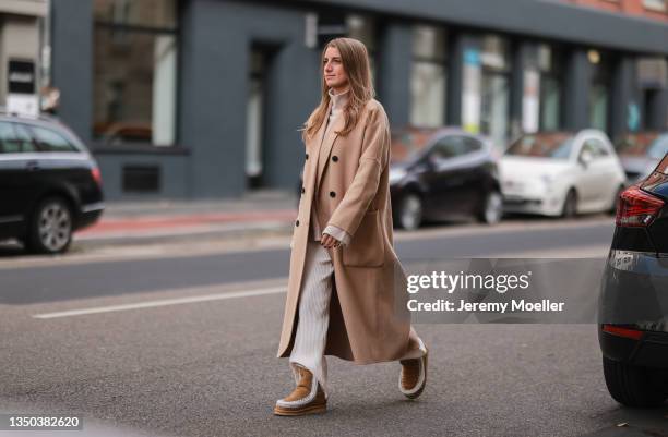 Charlotte Burbach wearing a Zara beige coat, H&M beige two piece and Mou Boots in brown on October 25, 2021 in Cologne, Germany.