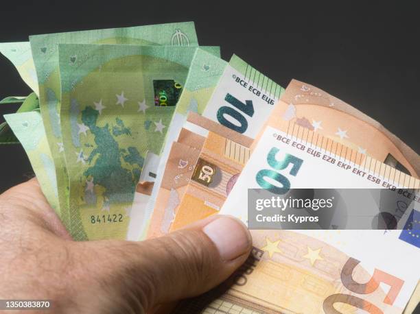 man's hand holding euro cash money - euroscheine stock-fotos und bilder