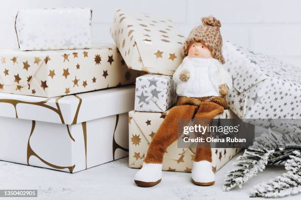 christmas gnome among many gift boxes. - holiday gnomes stock pictures, royalty-free photos & images
