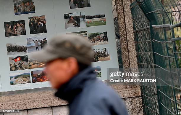 Chinese man walks past propaganda posters showing the North Korean leader Kim Jong-Il outside the North Korean embassy in Beijing on December 6,...