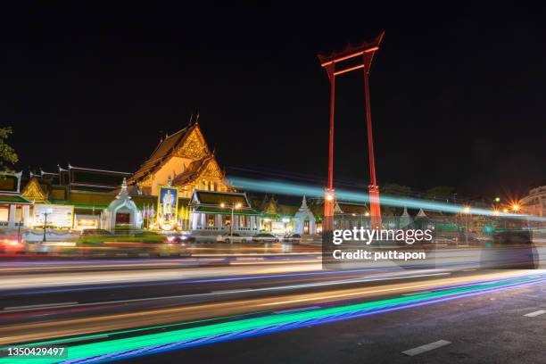 light trail at giant swing and suthat temple at twilight in bangkok - torii gates photos et images de collection