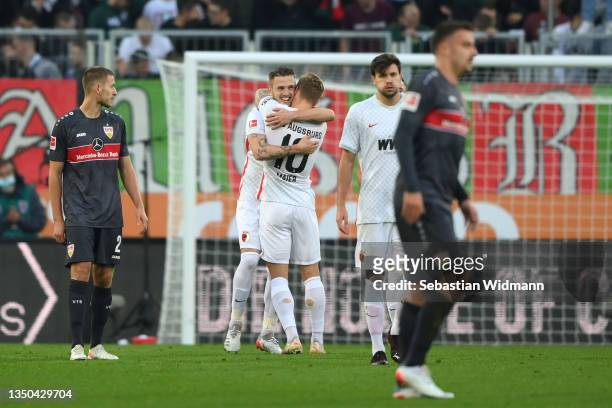 Jeffrey Gouweleeuw of FC Augsburg celebrates with teammate Arne Maier after scoring their side's second goal during the Bundesliga match between FC...