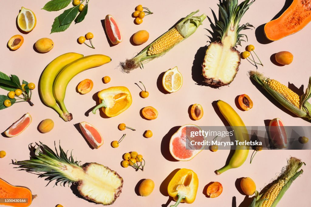 Many yellow fruits and vegetables on a yellow background.