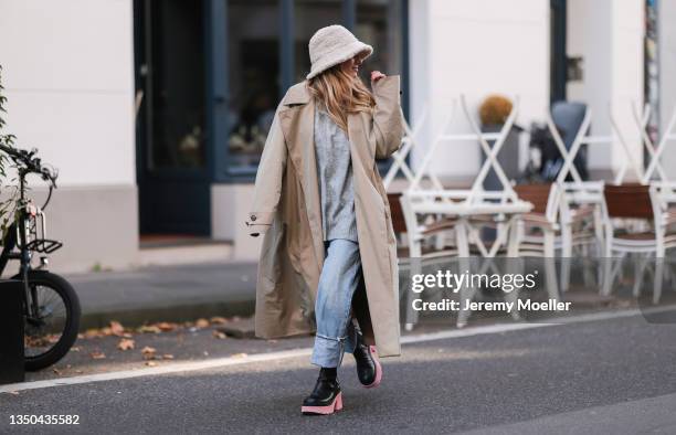 Michi Brandl wearing Karo Kaur beige bucket hat, Uniqlo beige trenchcoat, Just Female grey turtleneck, Agolde blue denim and Copenhagen Studios black...