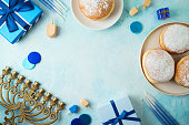 Frame border design for jewish holiday Hanukkah with traditional donuts, menorah and gift box. Top view, flat lay