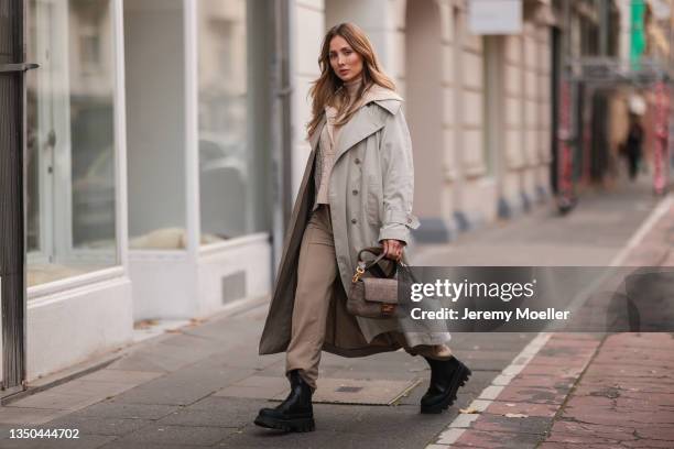 Carmen Kroll wearing Fendi baguette bag, Copenhagen Studios black boots, Oh April trenchcoat, Aeron beige sweater and Nakd brown pants on October 25,...