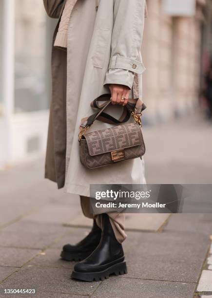 Carmen Kroll wearing Fendi baguette bag, Copenhagen Studios black boots, Oh April trenchcoat and Nakd brown pants on October 25, 2021 in Cologne,...