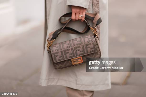 Carmen Kroll wearing Fendi baguette bag, Oh April trenchcoat and Nakd brown pants on October 25, 2021 in Cologne, Germany.