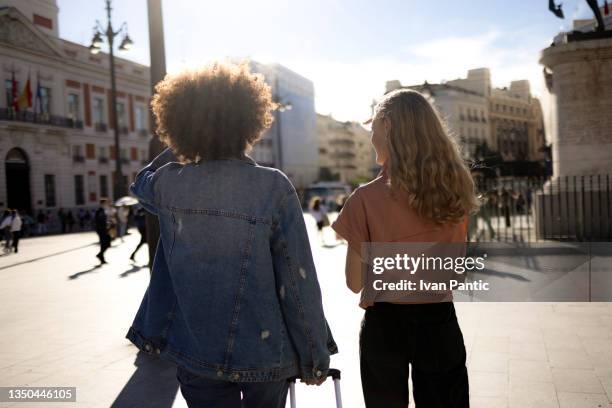 back view of two friends walking and talking - madrid stock pictures, royalty-free photos & images