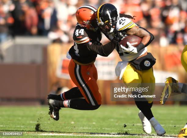 Anthony McFarland of the Pittsburgh Steelers carries the ball as he is tackled by Sione Takitaki of the Cleveland Browns in the first half at...