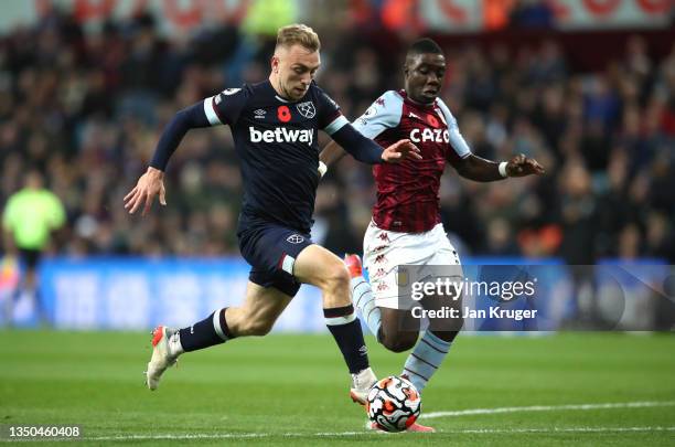 Jarrod Bowen of West Ham United runs with the ball whilst under pressure from Marvelous Nakamba of Aston Villa during the Premier League match...