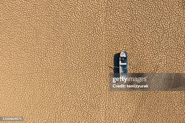 aerial view of a fishing boat on a drought dry lakebed. - desastre ambiental imagens e fotografias de stock