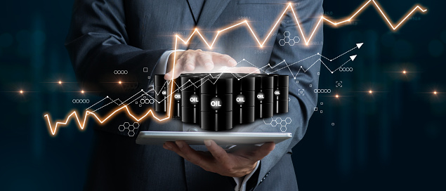 Businessman holding a group of barrels of oil with graphs of the stock market as a concept of raw material. 3D Render