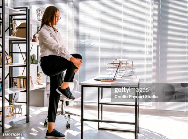woman stretching while working from a home office - human limb stock pictures, royalty-free photos & images