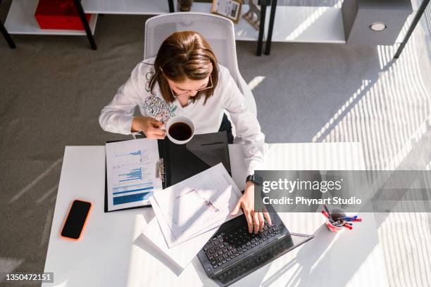 geschäftsfrau, die statistische geschäftsberichte auf ihrem laptop-pc im büro analysiert, eine overhead-ansicht - office work flat lay stock-fotos und bilder