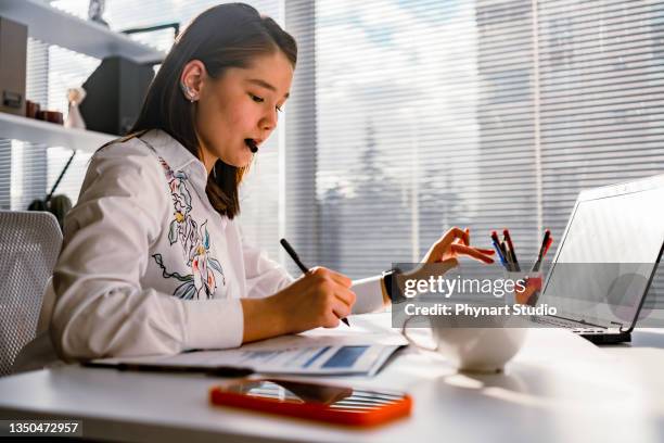 businesswoman analyzing statistical business reports on her laptop pc at the office. - design studio woman chinese laptop bildbanksfoton och bilder