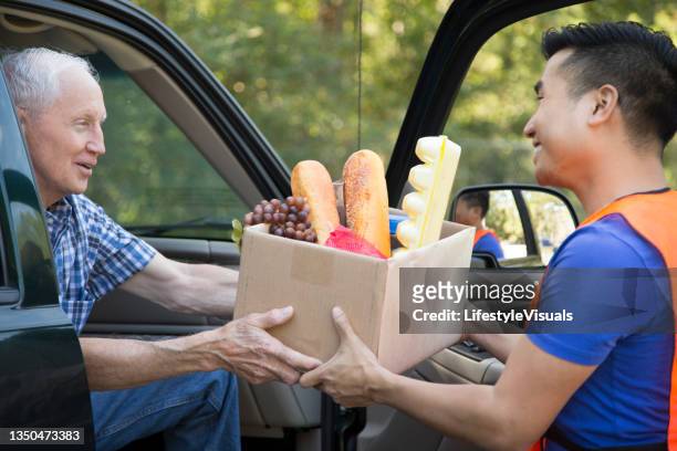 senior mann erhält oder spendet essen an / von wohltätigkeitsorganisationen für thanksgiving.  öffnen sie die autotür. - open source stock-fotos und bilder