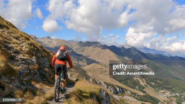 mountain biker follows trail on grassy mountain ridge - shorts down stock pictures, royalty-free photos & images