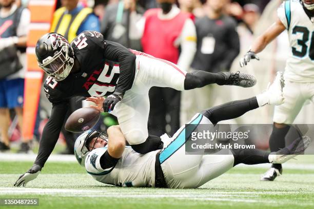 Deion Jones of the Atlanta Falcons tackles Sam Darnold of the Carolina Panthers in the fourth quarter at Mercedes-Benz Stadium on October 31, 2021 in...