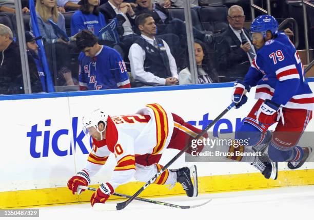 Andre Miller of the New York Rangers and Blake Coleman of the Calgary Flames collide at Madison Square Garden on October 25, 2021 in New York City.