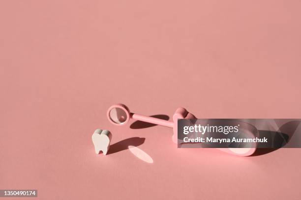 Toy dental Inspection mirror for teeth closure on pink background