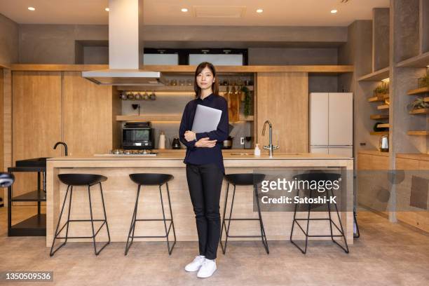 full length portrait of young female restaurant staff standing in front of kitchen - woman portrait kitchen laptop bildbanksfoton och bilder