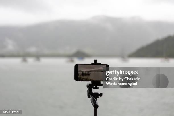 salak phet bay (koh chang island) - rain cloud, .mountain, rain forest and fisherman village) - mobile phone camera on tripod. - tripod stock pictures, royalty-free photos & images