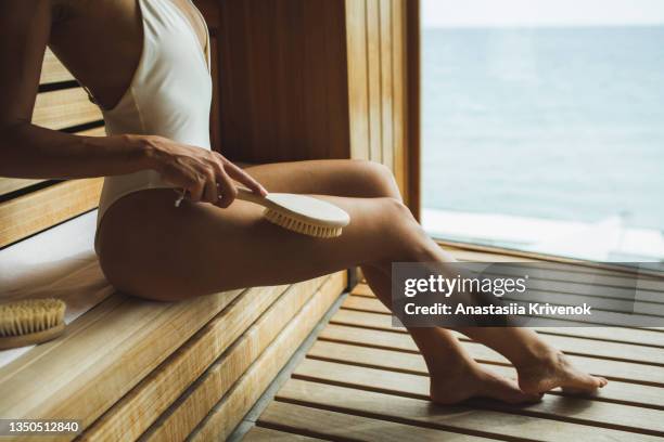 unrecognizable multiracial woman making anti cellulite or lymphatic thigh massage at sauna, closeup. - natural organic thermo cosmetics stock-fotos und bilder