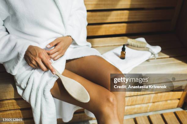 unrecognizable multiracial woman making anti cellulite or lymphatic thigh massage at sauna, closeup. - natural organic thermo cosmetics foto e immagini stock