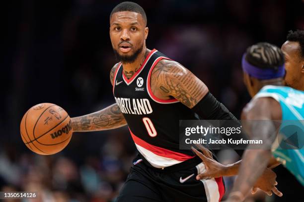 Damian Lillard of the Portland Trail Blazers brings the ball up court against the Charlotte Hornets during the first quarter during their game at...