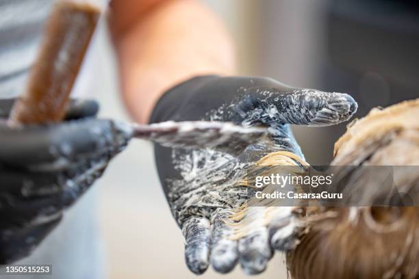 primo piano del parrucchiere che tinge i capelli dell'uomo - tintura per capelli foto e immagini stock