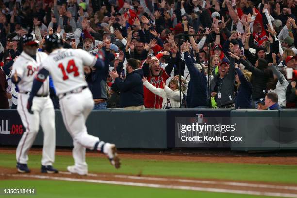 Fans celebrate a grand slam home run by Adam Duvall of the Atlanta Braves against the Houston Astros during the first inning in Game Five of the...