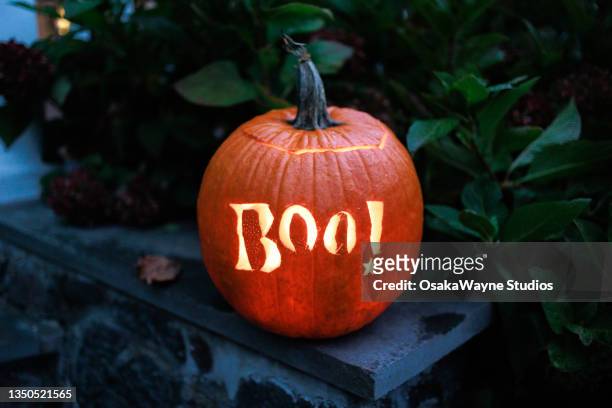 carved boo! lettering into orange round pumpkin - fries stockfoto's en -beelden