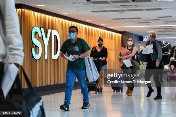 Passengers arrive from their overseas flights and walk to the arrivals hall after landing at Sydney Airport on November 01, 2021 in Sydney,...