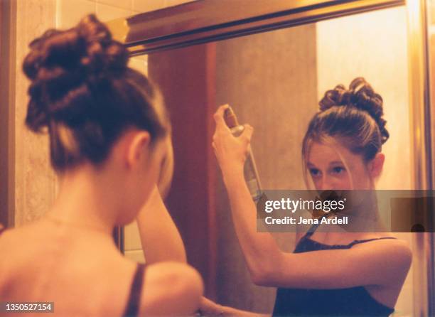 1990s teen using hairspray in hair updo before school dance vintage photograph - bad bangs stock-fotos und bilder