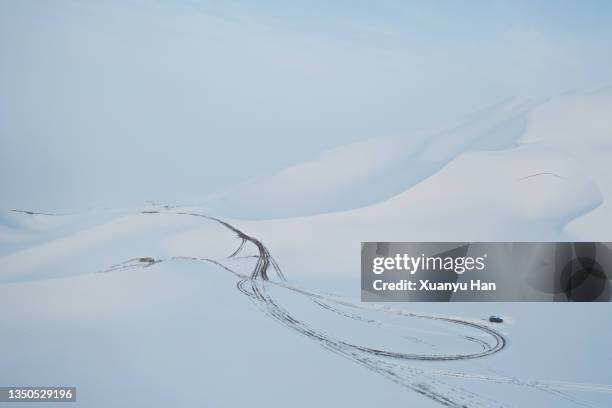 the car is driving in the snow-covered desert - snowfield fotografías e imágenes de stock