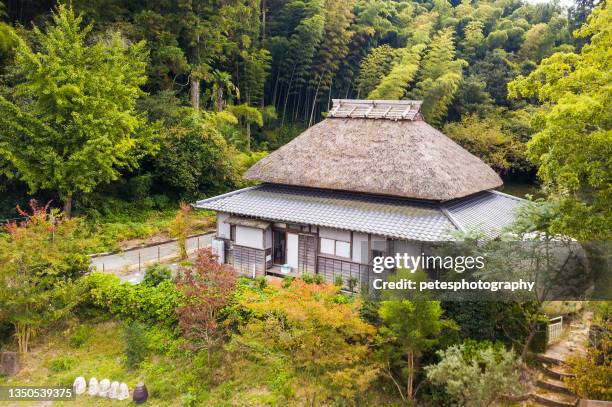 a traditional old style japanese house with straw thatched roof in the country side - tradition stock pictures, royalty-free photos & images