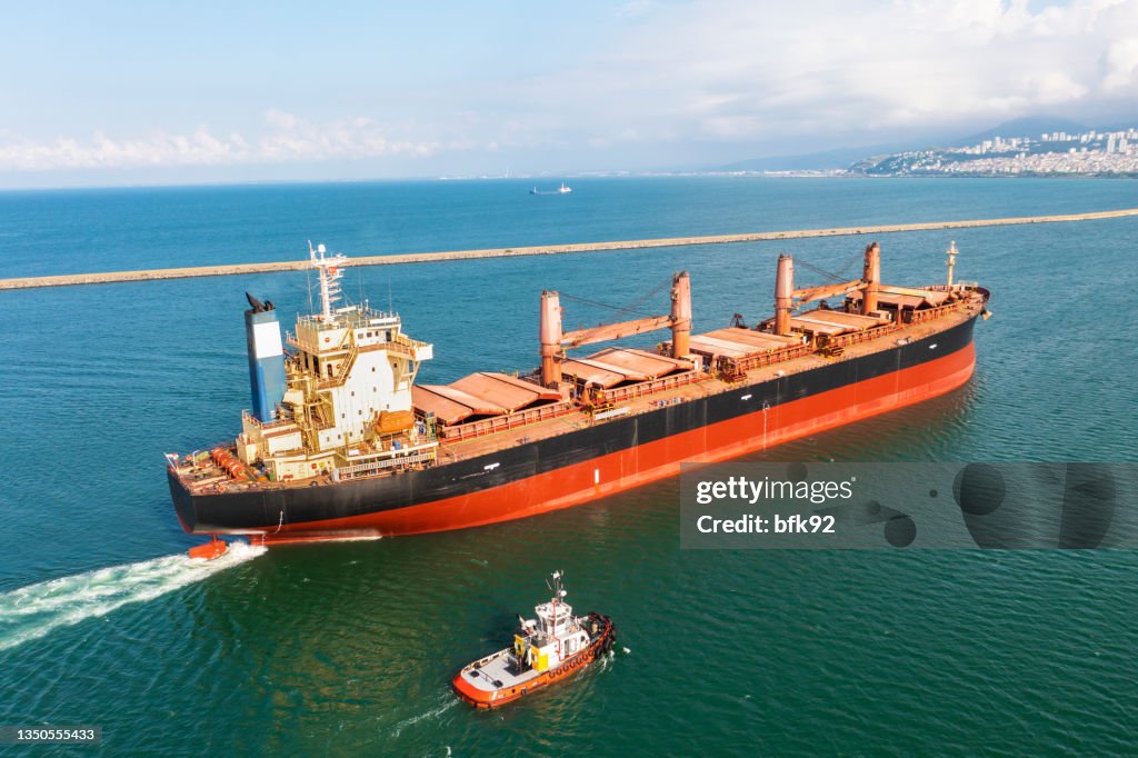 Aerial view of large bulk carrier approaching port.