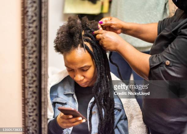 woman in salon having her hair braided by a stylist - braided hair imagens e fotografias de stock