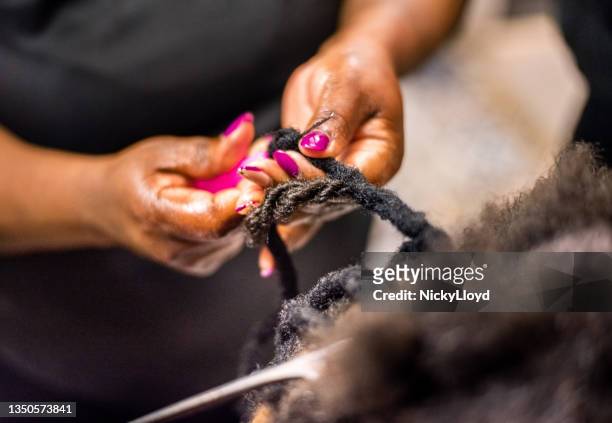 hairstylist braiding and extending customer's hair - hairdressers black woman stock pictures, royalty-free photos & images